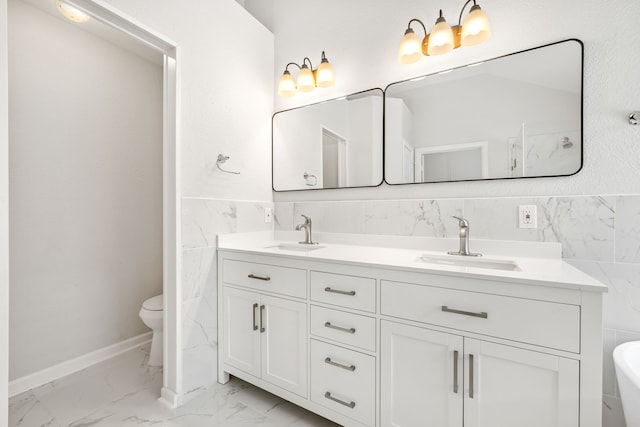 bathroom with tile walls, toilet, marble finish floor, and a sink