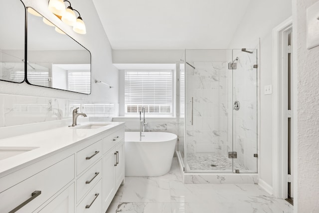 full bath featuring a marble finish shower, double vanity, a freestanding tub, a sink, and marble finish floor