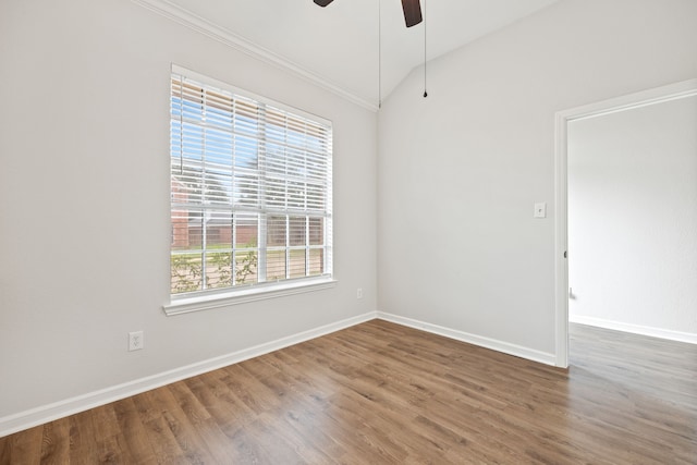 empty room with crown molding, baseboards, lofted ceiling, wood finished floors, and a ceiling fan