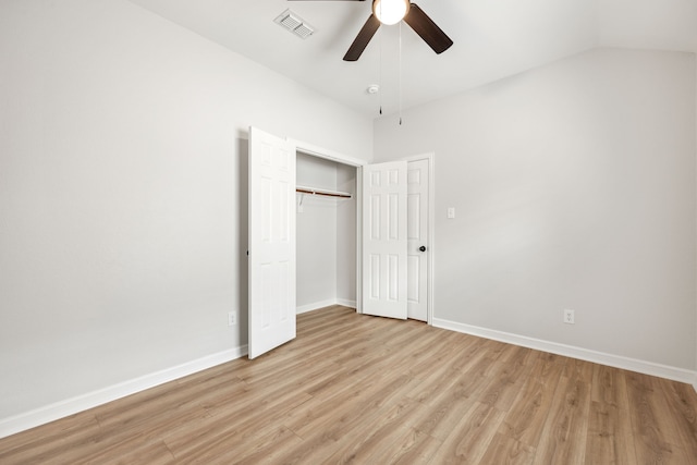 unfurnished bedroom with baseboards, visible vents, light wood finished floors, vaulted ceiling, and a closet