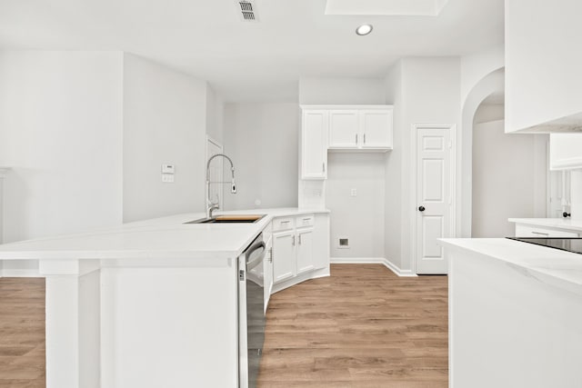 kitchen with visible vents, a sink, light wood-style flooring, white cabinetry, and stainless steel dishwasher