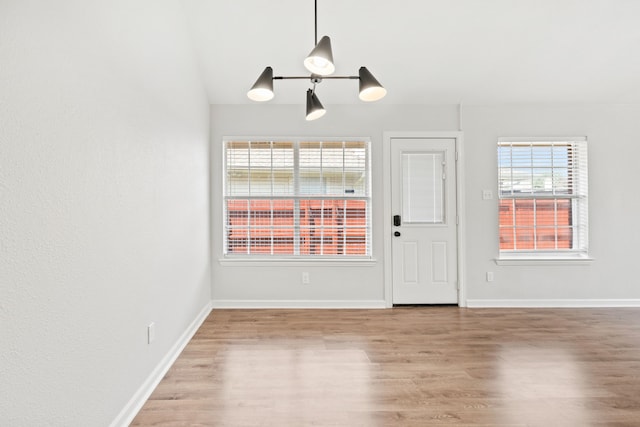 foyer with plenty of natural light, wood finished floors, and baseboards