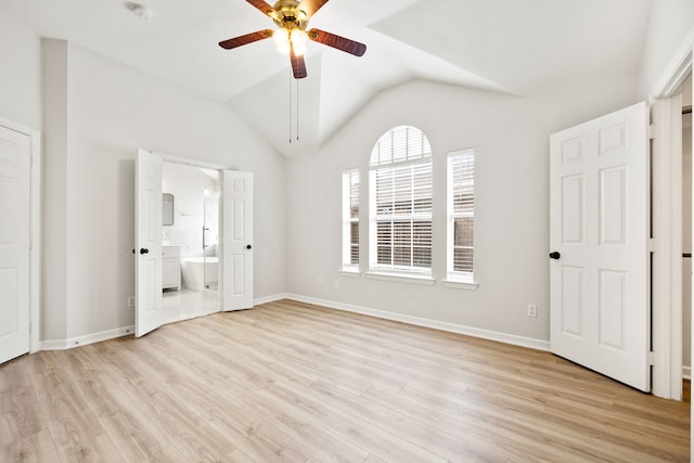 unfurnished bedroom featuring ensuite bath, vaulted ceiling, baseboards, and light wood finished floors