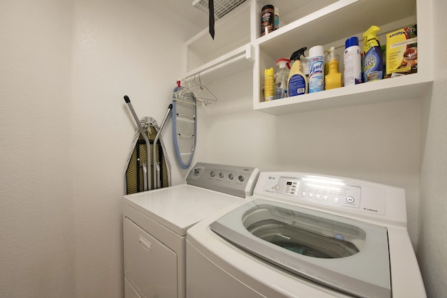 clothes washing area with washing machine and dryer and laundry area