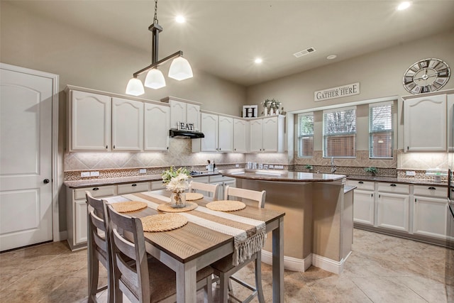 kitchen featuring under cabinet range hood, visible vents, and white cabinets