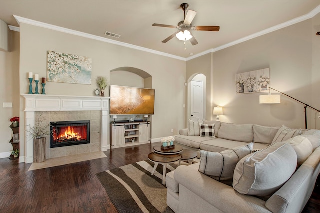 living room featuring visible vents, baseboards, dark wood-style floors, and crown molding