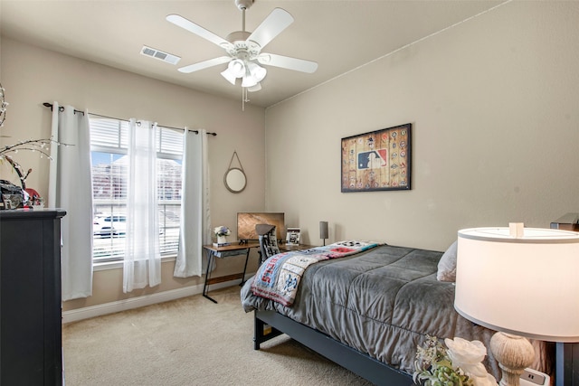 carpeted bedroom with visible vents, baseboards, and a ceiling fan