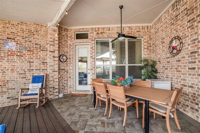 wooden deck featuring outdoor dining area and a ceiling fan