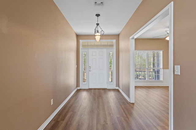 foyer entrance featuring visible vents, baseboards, and dark wood-style flooring