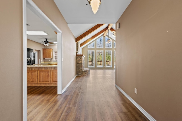 hallway with lofted ceiling with beams, baseboards, and dark wood finished floors