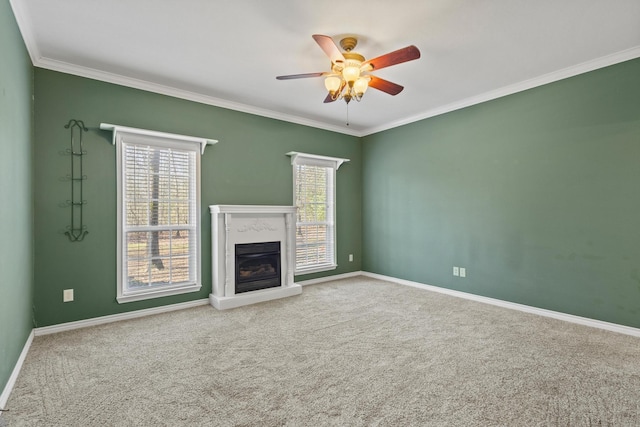 unfurnished living room featuring a wealth of natural light, carpet flooring, ornamental molding, and a fireplace