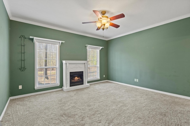 unfurnished living room with a ceiling fan, carpet floors, ornamental molding, and a wealth of natural light
