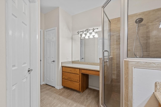 full bath featuring wood finished floors, a stall shower, and vanity