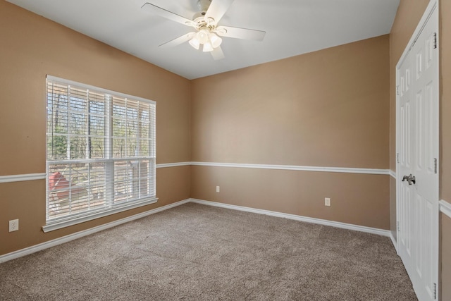 spare room featuring carpet flooring, baseboards, and a ceiling fan