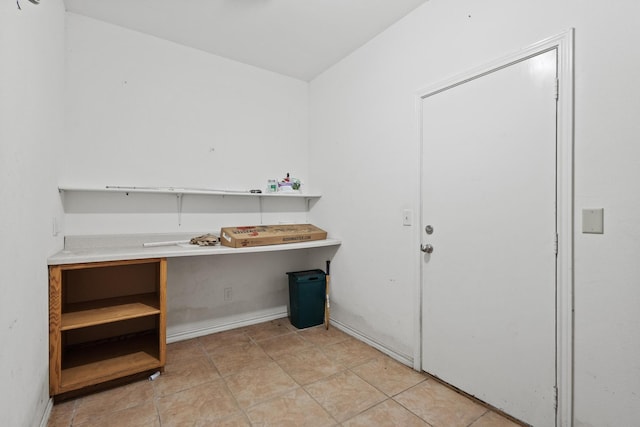 clothes washing area with light tile patterned floors