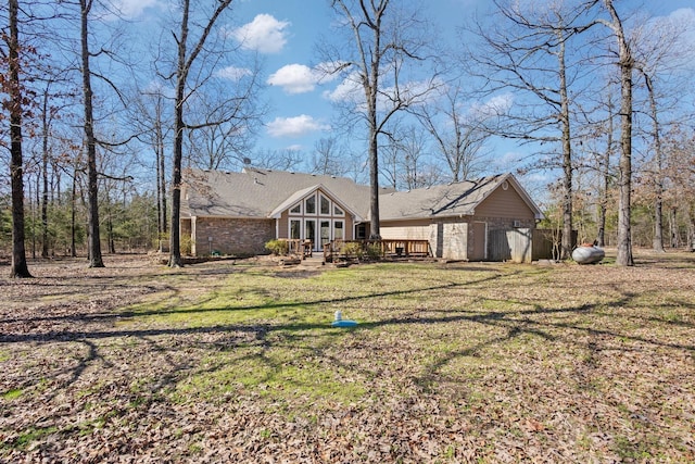 view of front of house with a front lawn, brick siding, and a wooden deck