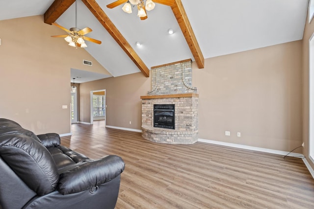 living room with visible vents, a brick fireplace, baseboards, light wood-type flooring, and beam ceiling