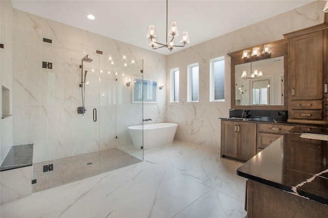 full bath featuring vanity, a marble finish shower, a freestanding bath, a notable chandelier, and marble finish floor