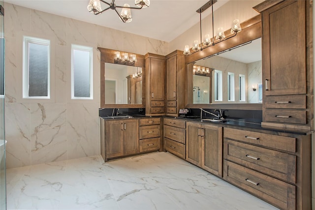 bathroom featuring a sink, marble finish floor, an inviting chandelier, and double vanity