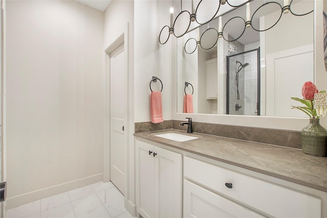 full bathroom featuring marble finish floor, a stall shower, vanity, and baseboards