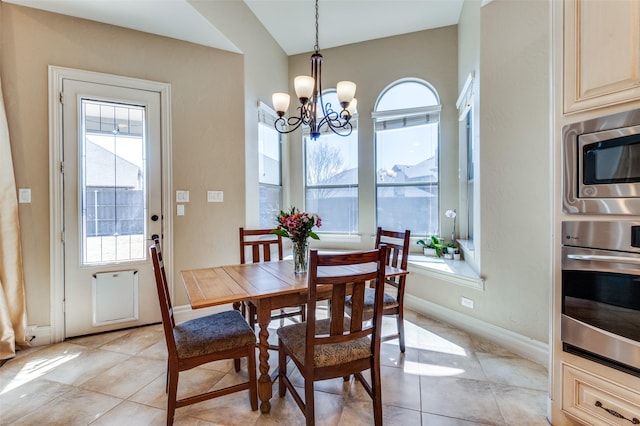 dining space featuring a notable chandelier, baseboards, and light tile patterned floors