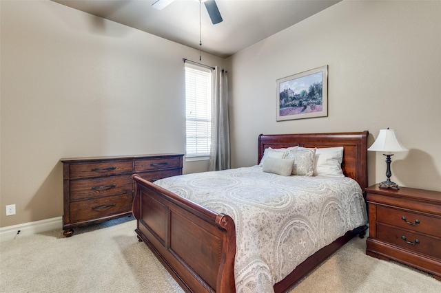 bedroom with a ceiling fan, light colored carpet, and baseboards