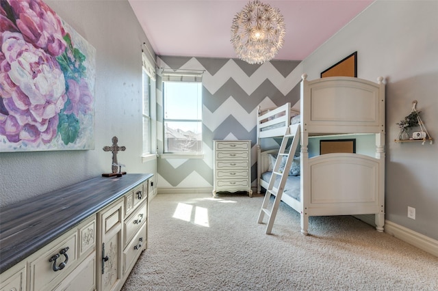 bedroom featuring a notable chandelier, wallpapered walls, baseboards, light colored carpet, and an accent wall