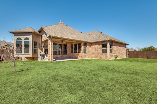 back of house with a patio, a ceiling fan, fence, a lawn, and brick siding