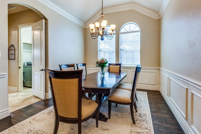 dining room with arched walkways, an inviting chandelier, crown molding, and lofted ceiling