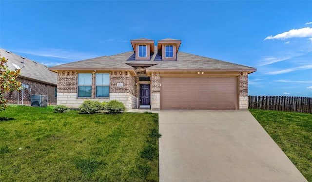 view of front facade featuring a front yard, fence, a garage, and driveway