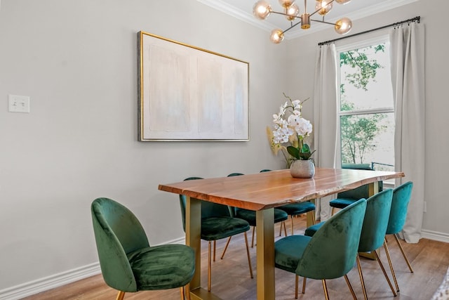 dining space with a notable chandelier, ornamental molding, baseboards, and wood finished floors