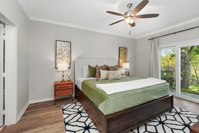 bedroom with access to exterior, crown molding, wood finished floors, and baseboards