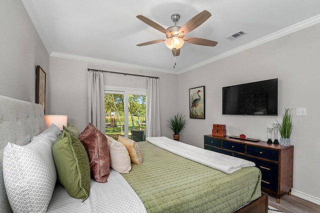 bedroom featuring visible vents, crown molding, ceiling fan, baseboards, and wood finished floors