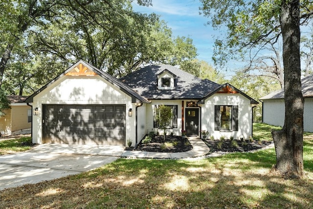 modern farmhouse style home featuring concrete driveway, an attached garage, and a shingled roof