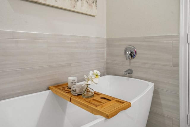 full bathroom with a soaking tub and tile walls