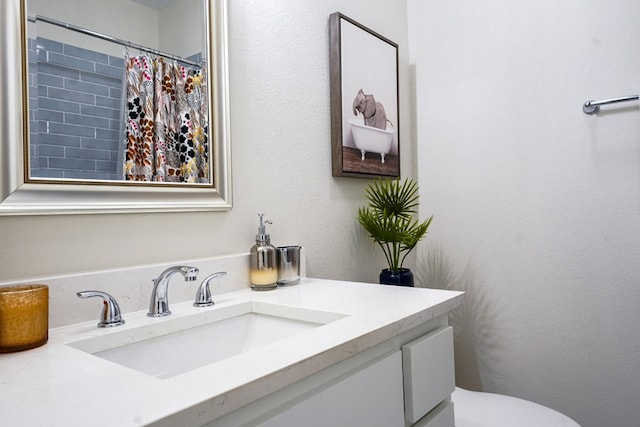 bathroom with toilet, vanity, and a shower with curtain