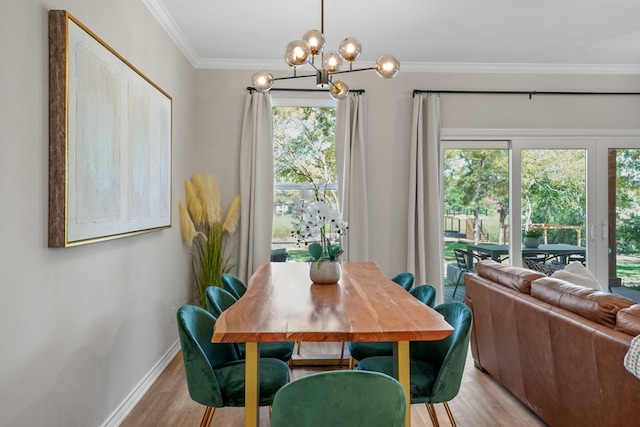 dining space featuring plenty of natural light, light wood-style floors, a chandelier, and ornamental molding