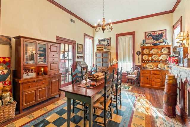 dining space with visible vents, a wealth of natural light, a chandelier, and wood-type flooring