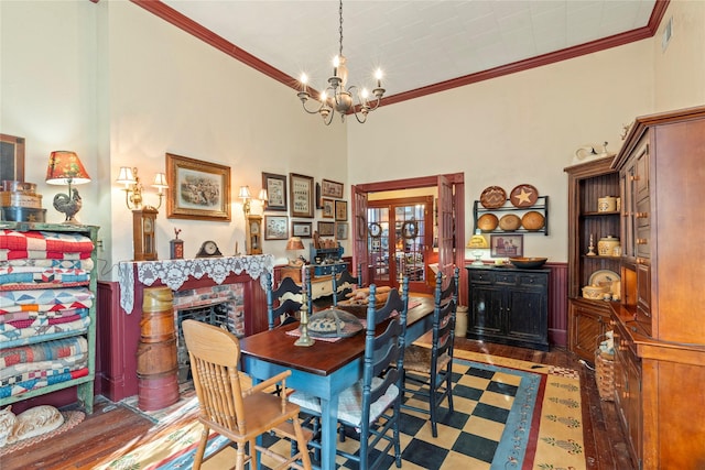 dining room featuring french doors, wood finished floors, a chandelier, and ornamental molding