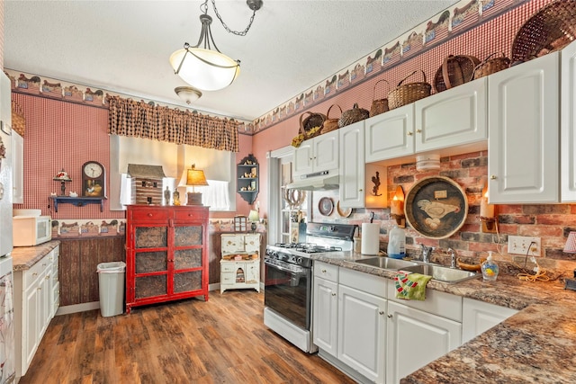 kitchen featuring white cabinets, a sink, white microwave, gas range oven, and under cabinet range hood