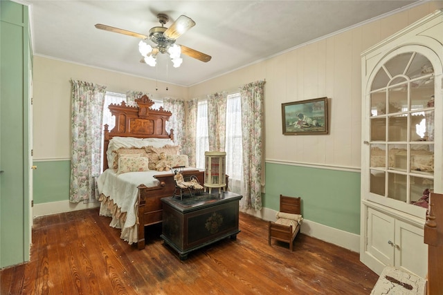 bedroom with wood finished floors, baseboards, and ornamental molding