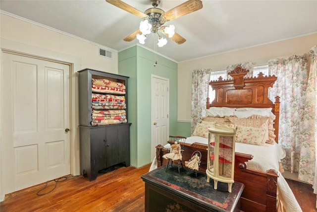 dining room with wood finished floors, visible vents, crown molding, and a ceiling fan
