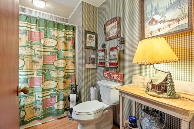 bathroom with curtained shower, wallpapered walls, wood finished floors, toilet, and ornamental molding