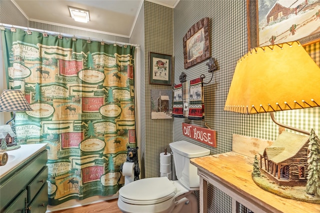 bathroom with curtained shower, wallpapered walls, toilet, vanity, and ornamental molding