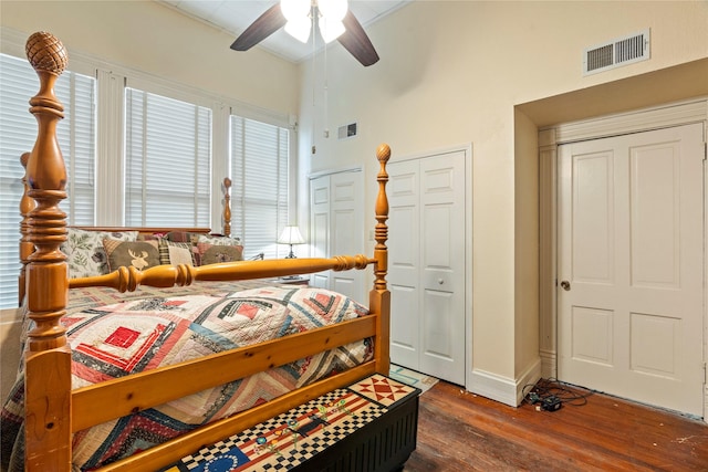 bedroom featuring baseboards, a ceiling fan, wood finished floors, and visible vents