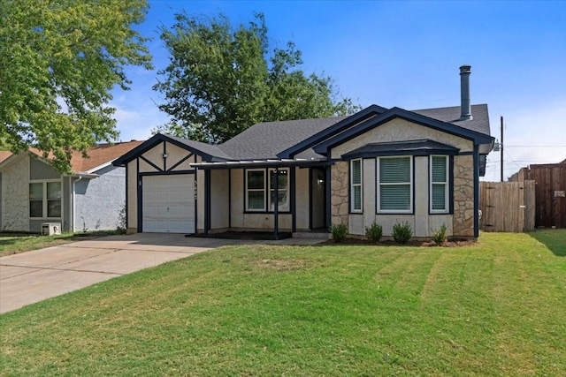 view of front of property with an attached garage, fence, a front yard, stone siding, and driveway