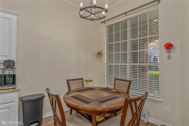 dining room featuring a chandelier, baseboards, light wood-style floors, and ornamental molding