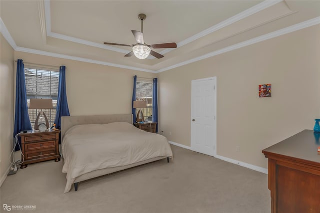 carpeted bedroom featuring baseboards, a raised ceiling, ceiling fan, and crown molding