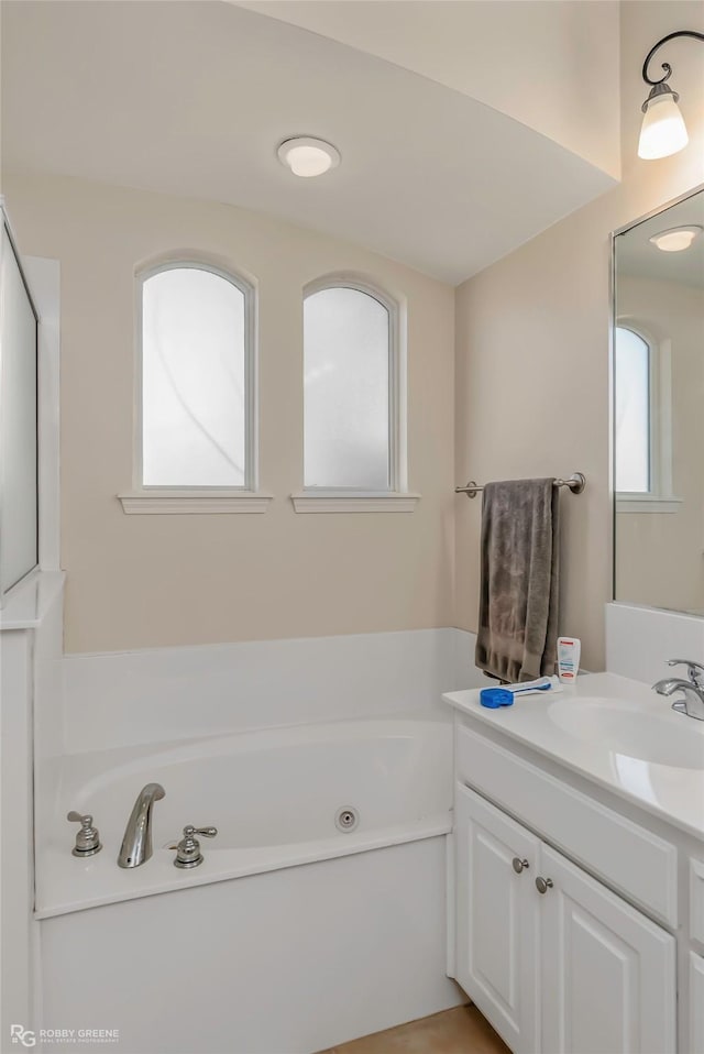 full bath featuring a jetted tub and vanity