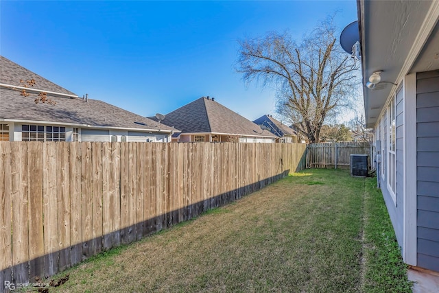 view of yard with central air condition unit and a fenced backyard